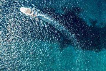 Stunning aerial view of boats along the vibrant coastline of Croatia, capturing the crystal-clear blue water.