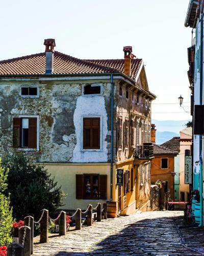 Sunlit cobblestone street in picturesque Motovun, Croatia, capturing vintage Italian-style architecture.