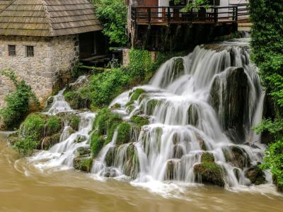 Captivating waterfall next to an old mill in Slunj, showcasing natural beauty and Croatian heritage.