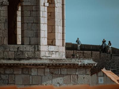 Close-up of Dubrovnik's historic stone tower and city walls under a clear sky.