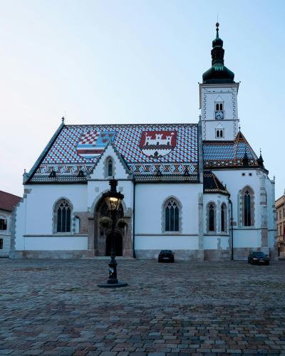 Stunning view of St. Mark's Church in Zagreb's historic square, featuring its vibrant tiled roof at dusk.