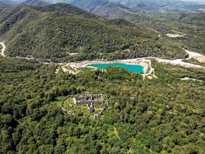 A spectacular aerial view of ancient ruins surrounded by lush greenery and a turquoise lake in Orahovica, Croatia.