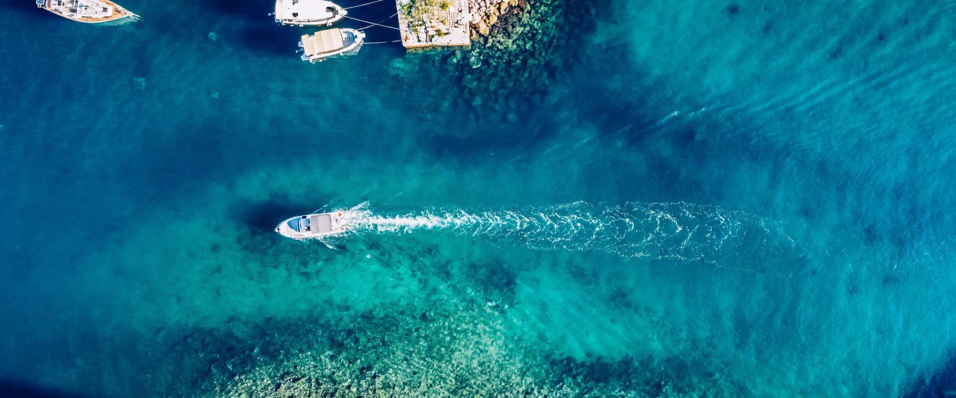 Stunning aerial view of boats and clear turquoise waters along the Adriatic coast in Dubrovnik, Croatia.