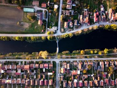 Aerial view of a neighborhood and river in Vinkovci, Croatia, showcasing houses and a bridge.