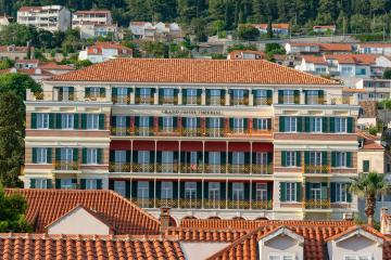 Stunning facade of a luxury hotel in Dubrovnik, showcasing classic architecture under a summer sky.