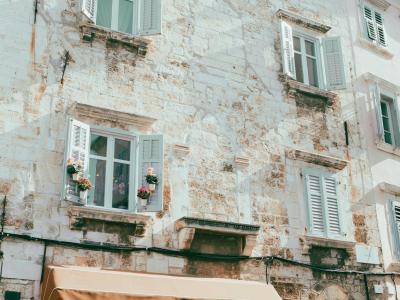 Explore the charming historic architecture of Pula, Croatia with rustic stone buildings and quaint windows.