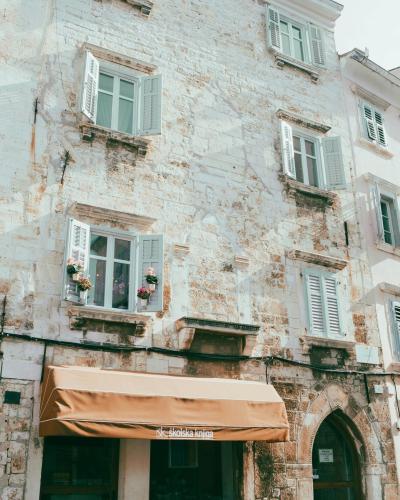 Explore the charming historic architecture of Pula, Croatia with rustic stone buildings and quaint windows.