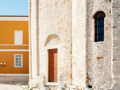 Detail of a stone church wall with historical architecture in Zadar.