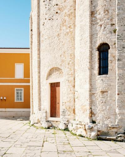 Detail of a stone church wall with historical architecture in Zadar.